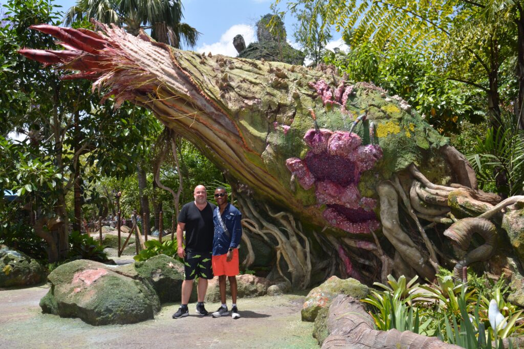 Us in front of the Flaska Reclinata in Pandora - The World of Avatar inside Disney's Animal Kingdom. Go ahead and touch this plant and see what it does.