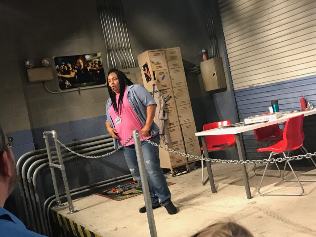 A live actor warms up the crowd in the break room pre-show for Fast & Furious Supercharged ride at Universal Studios Orlando
