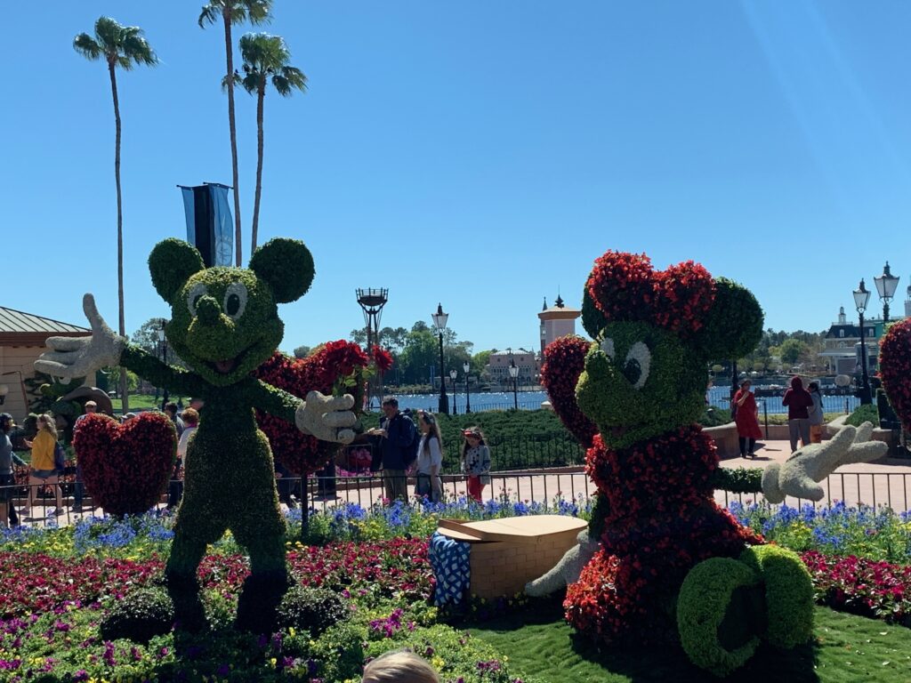 Mickey and Minnie Mouse are in the large garden in the center of Showcase Plaza