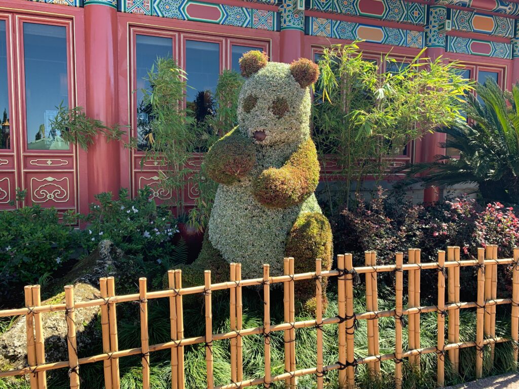 A giant panda behind a bamboo fence (which is new this year) can be found in China